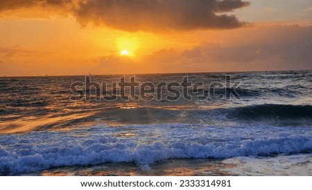 Orange Sunrise on the Ocean Horizon. The sky is ablaze with vivid shades of orange, casting a warm glow over the tranquil waters. Beautiful ocean. Amazing sunrise at the beach.