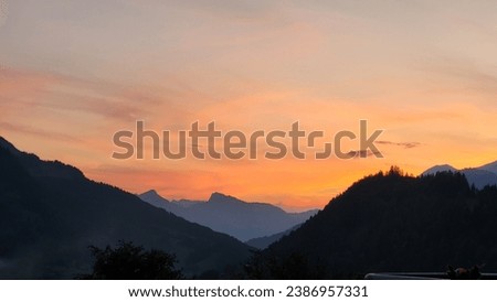 orange sunset behind the mountains