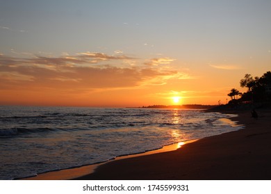 Orange sunset by the beach with sunlight reflection on the sea.