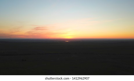 Orange Sunset On The Background Of A Poppy Field. Top View From A Drone On Purple-orange Clouds, Dark Earth. Night Falls. Clear Sky. Kazakhstan, Almaty.