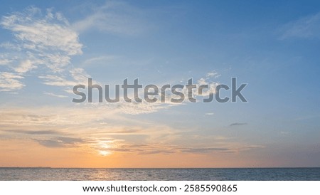 Orange sunset sky clouds over sea in the evening with yellow sunlight, Horizon sea blue sky landscape background and sun down in golden hour summer season, Dusk sky