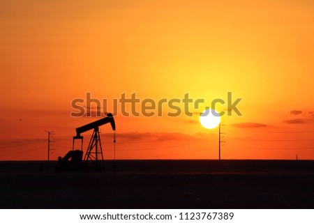 orange sunset sky and pump jack silhouette