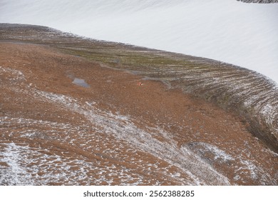 Orange tent on snowy stony pass under wide big snow-white glacier in high mountains. Alpine valley and large snowfield on rocky hill slope close up. Texture of mountain terrain in freshly fallen snow. - Powered by Shutterstock