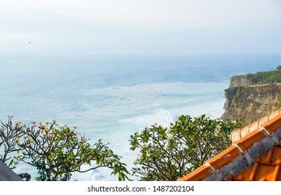 Orange tiled roof on a background of ocean coast near the temple of Uluwatu, Bali, Indonesia