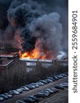 Orange toxic smoke from flames or fires of warehouses and industrial building. Burning house or adjacent area requiring the arrival of fire and rescue personnel due to fire safety violations.