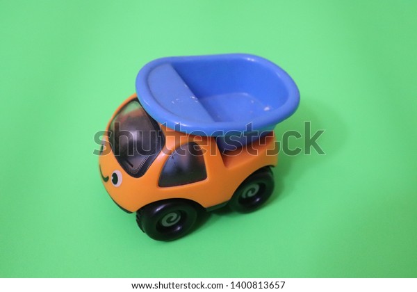 Orange Toy Car With in\
Green Background 