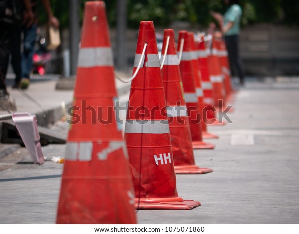 Orange traffic cones lined up to protect road users\
from harm. And prevent unrelated people from entering the\
workplace. By the traffic cones, the longitudinal road from the\
repair point to the end.