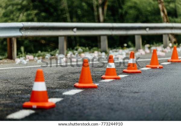 orange\
traffic cones standing in row on mountain\
road
