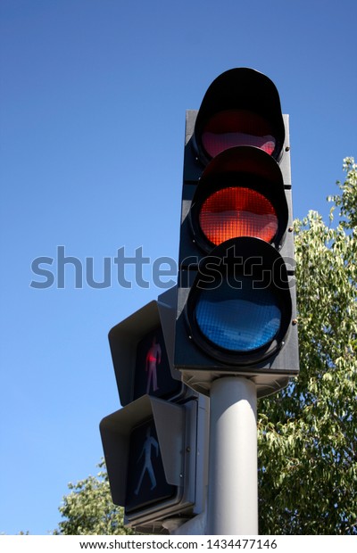 Orange\
traffic light for the cars and red for\
pedestrians