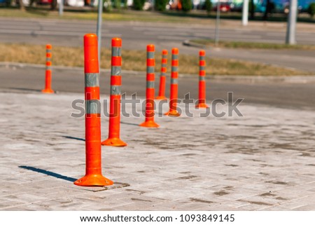 Orange traffic pillar on the road and on parking lane.