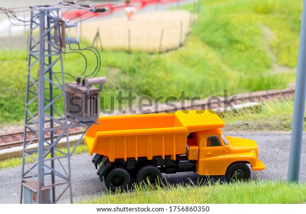 Orange truck in H0\
scale on model train\
road