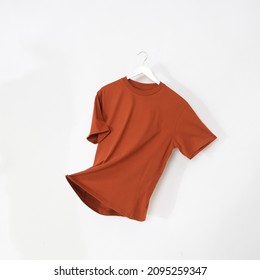 Orange tshirt with hanger. Flying cotton T-shirt isolated on white background. - Shutterstock ID 2095259347