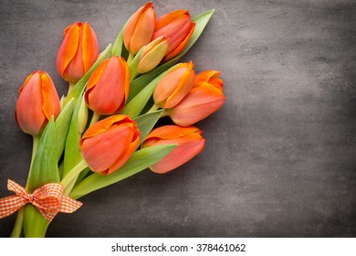 Orange tulips on the grey  background.