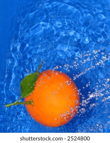 An Orange Under A Water Stream On Blue Background