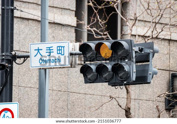 Orange Warning Traffic light installed at\
Otemachi intersection in downtown Tokyo, Japan to warn car driver\
to stop and prevent accident or vehicle crash. The Sign in Japanese\
said \