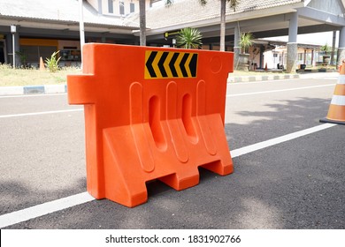 Orange water barrier on road, water-filled plastic barriers. 