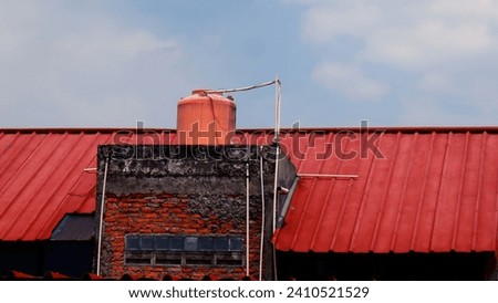 an orange water tank installation on the roof of the house.