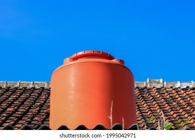 Orange Water Tank Kept On Clay Tile Isolated Blue Sky