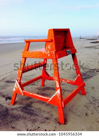 Orange weathered Lifeguard chair on the beach.