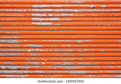 Orange Weathered Metallic Roll Up Door. Rusty Iron Gate.