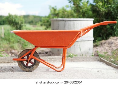 Orange Wheel Barrow Cart Trolley That Use For Construction To Carry Cement Mixture. Concept : Construction Worker's  Tool.