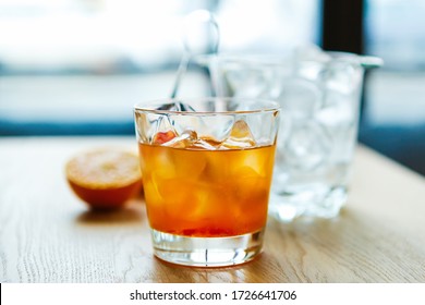 Orange Whisky With Ice In Glass.Refreshing Strong Alocoholic Long Drink On Table Mixed By Bartender In Bar.Strong Cocktail With Bourbon Whiskey,oranges Slice.Tasty Fresh Alcoholic Cocktails For Party 