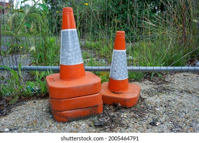 Orange And White Reflective Traffic Cones Stacked On Derelict Site