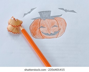 Orange wooden pencil sharpener placed pumpkin picture paper 