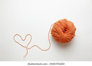 Orange yarn and knitting needles isolated on white background