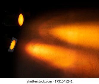 orange or yellow floodlight creating pattern on textured wall