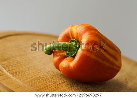 Orange and yellow pepper on the wooden board