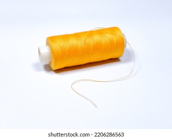 Orange or yellow sewing thread. Isolated on white background - Shutterstock ID 2206286563
