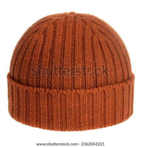 Orange-brown knitted winter bobble hat of traditional design isolated on white background