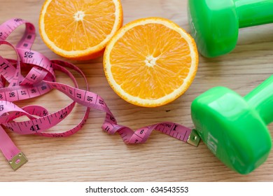 Oranges Close Up With Measuring Tape And Dumb Bells.Diet And Loss Weight Concept Related 