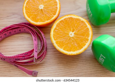 Oranges Close Up With Measuring Tape And Dumb Bells.Diet And Loss Weight Concept Related 