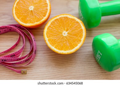 Oranges Close Up With Measuring Tape And Dumb Bells.Diet And Loss Weight Concept Related 