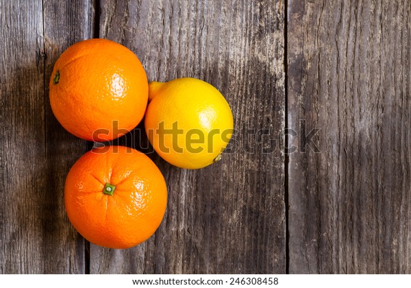 oranges and lemon on textured weathered wooden table\
- top view