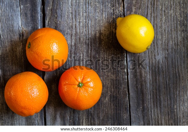 oranges and lemon on textured weathered wooden table
- top view