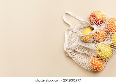 Oranges in mesh bag with design space on beige background - Powered by Shutterstock