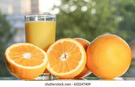 Oranges and orange juice on a green background.