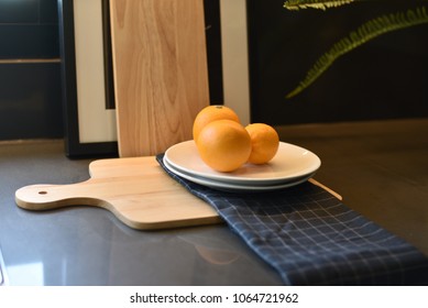 Oranges placed on a white plate in the kitchen room - Shutterstock ID 1064721962