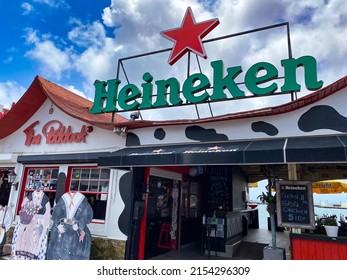 Oranjestad, Aruba -2022: Eetcafé The Paddock, open-air casual Dutch Cafe and bar on Oranjestad's harbor and Wharfside Market. Heineken beer sign in the Dutch Caribbean island. Cow spots. 