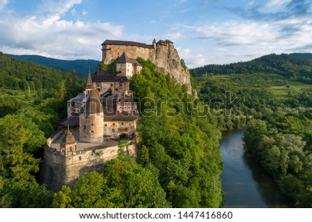 Orava castle - Oravsky Hrad in Oravsky Podzamok in Slovakia. Medieval stronghold on extremely high and steep cliff by the Orava river. Aerial view in sunrise light in summer