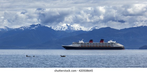 Orca Whales And Cruise Liner Are Shown On Snow Mountains Background, Alaska, The USA