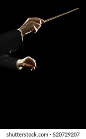 Orchestra Conductor Music Conducting. Conductors Hands With Baton Stick Isolated On Black Background