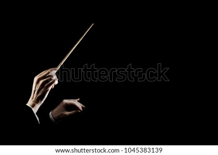 Orchestra conductor music conducting. Hands of conductor with baton isolated on black background