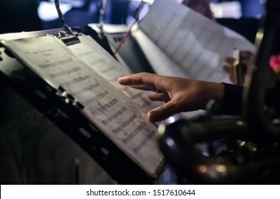 Orchestra Music Stands. Performance On The Stage Of A Brass Symphony Orchestra. Musician Reads Musical Notes.