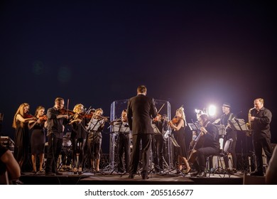 Orchestra performing live concert under blue night sky