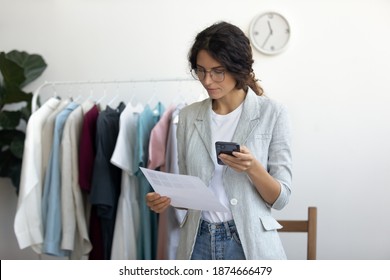 Order by cell. Young businesswoman qualified tailor selecting sample of fabric from catalogue. Female designer choosing colors of textile patterns by swatches palette to buy online at supplier website - Powered by Shutterstock