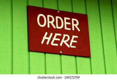 Order Here Sign On Green Wall Stock Photo (Edit Now) 149272709
